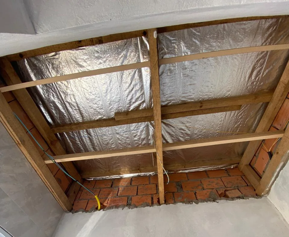 Manta térmica aluminizada instalada sob o telhado, entre a estrutura de madeira, antes do forro