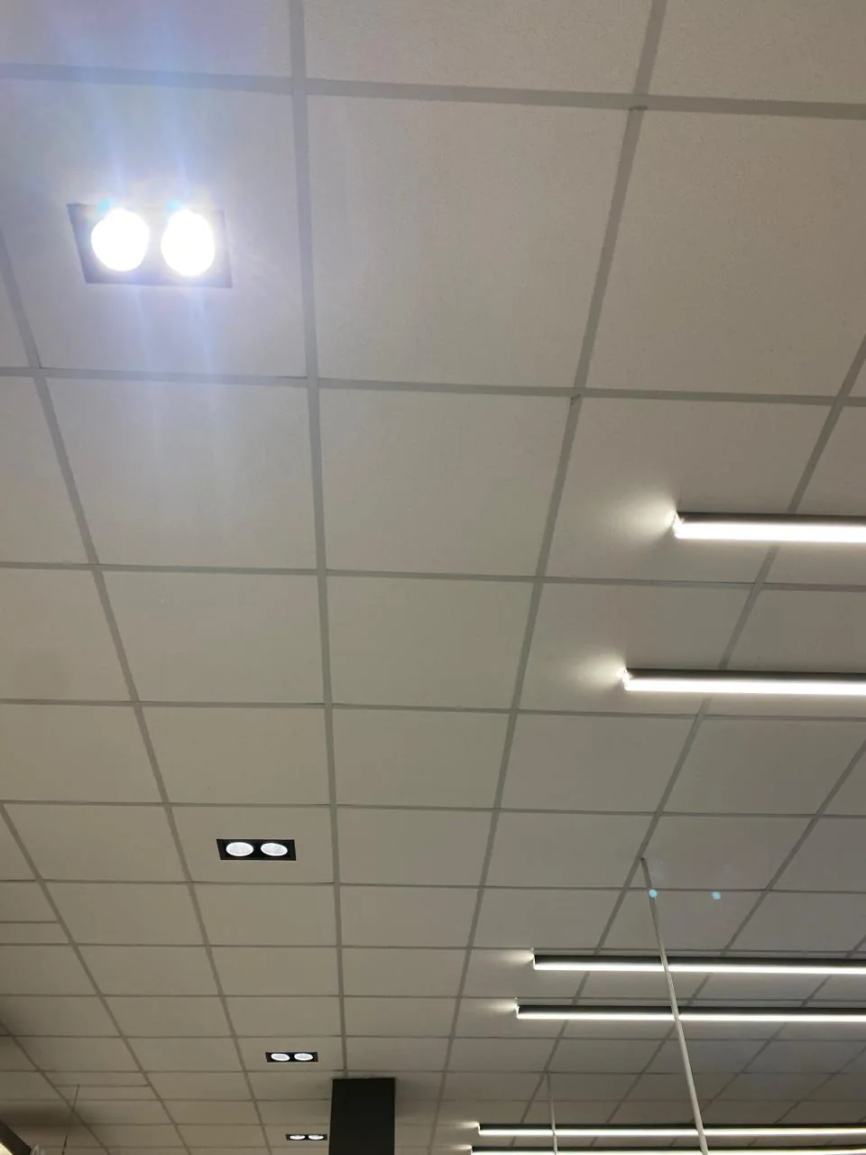 Forro modular branco com luminárias lineares e spots