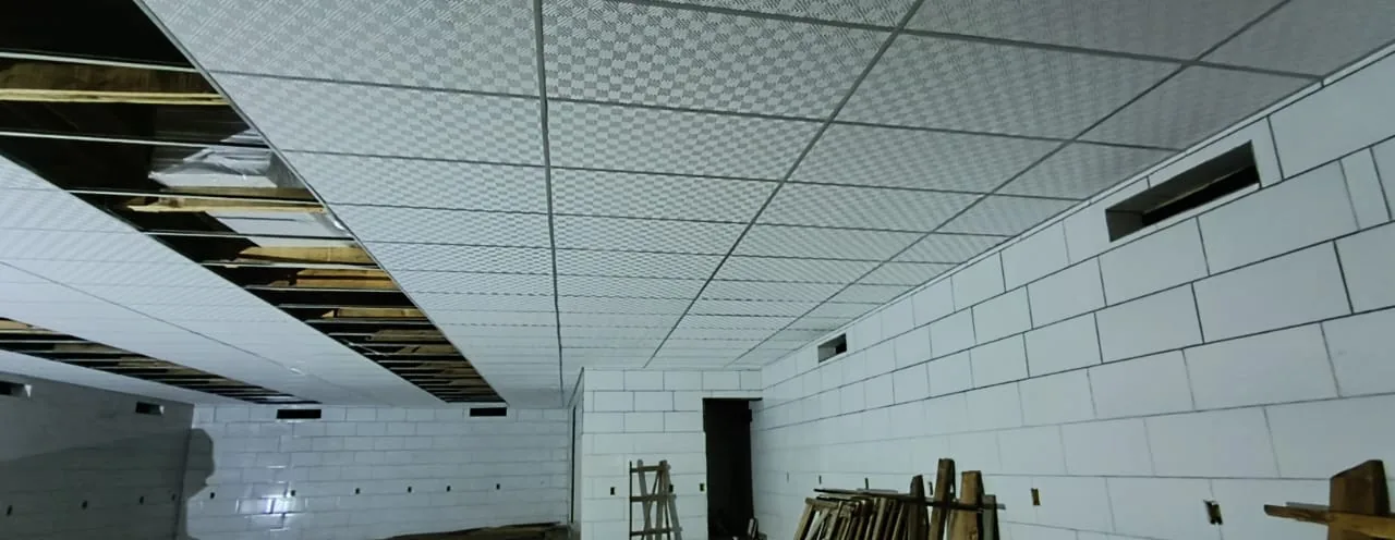 Obra da loja com a estrutura do forro modular e as placas sendo colocadas