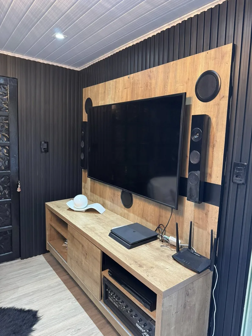 Painel ripado escuro na parede da sala de TV