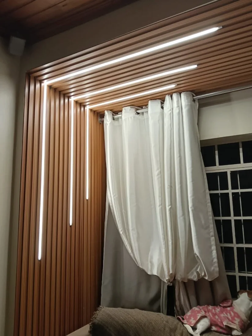 Painel ripado com fita de luz ao lado da janela